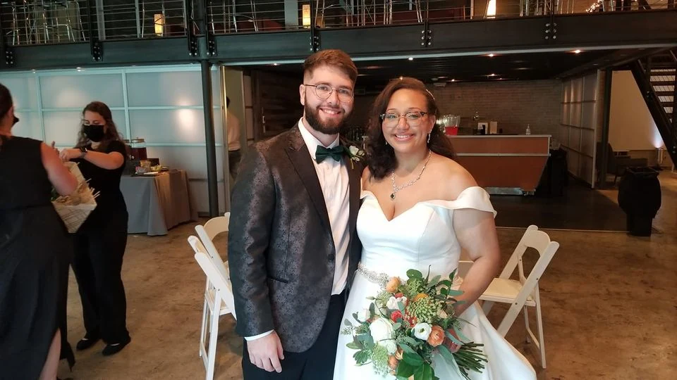 Newlyweds with a wedding bouquet at their venue