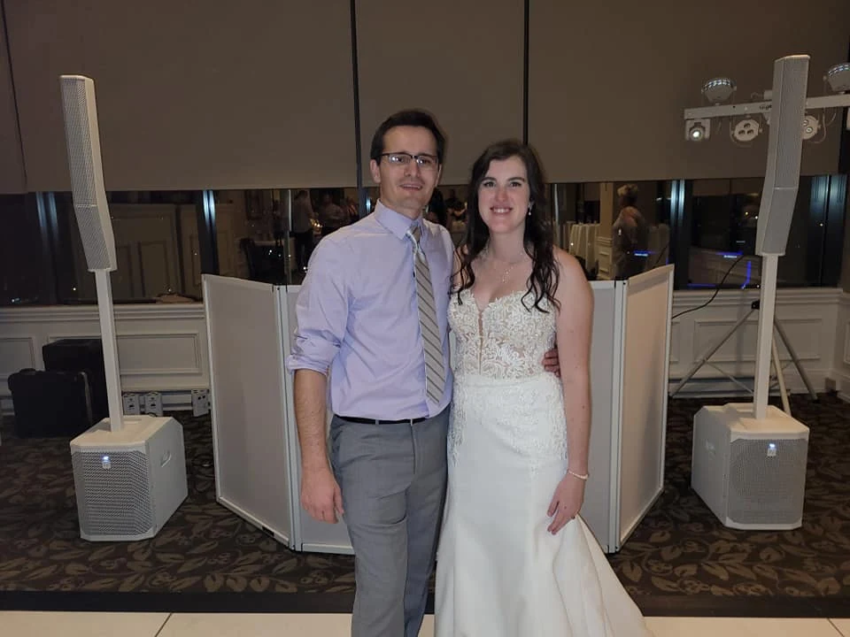 Newlyweds standing in front of the S and D DJ setup