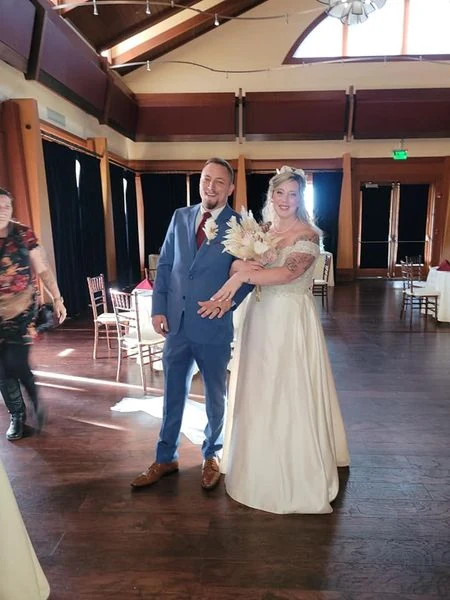 A wedding couple smiling together at their venue
